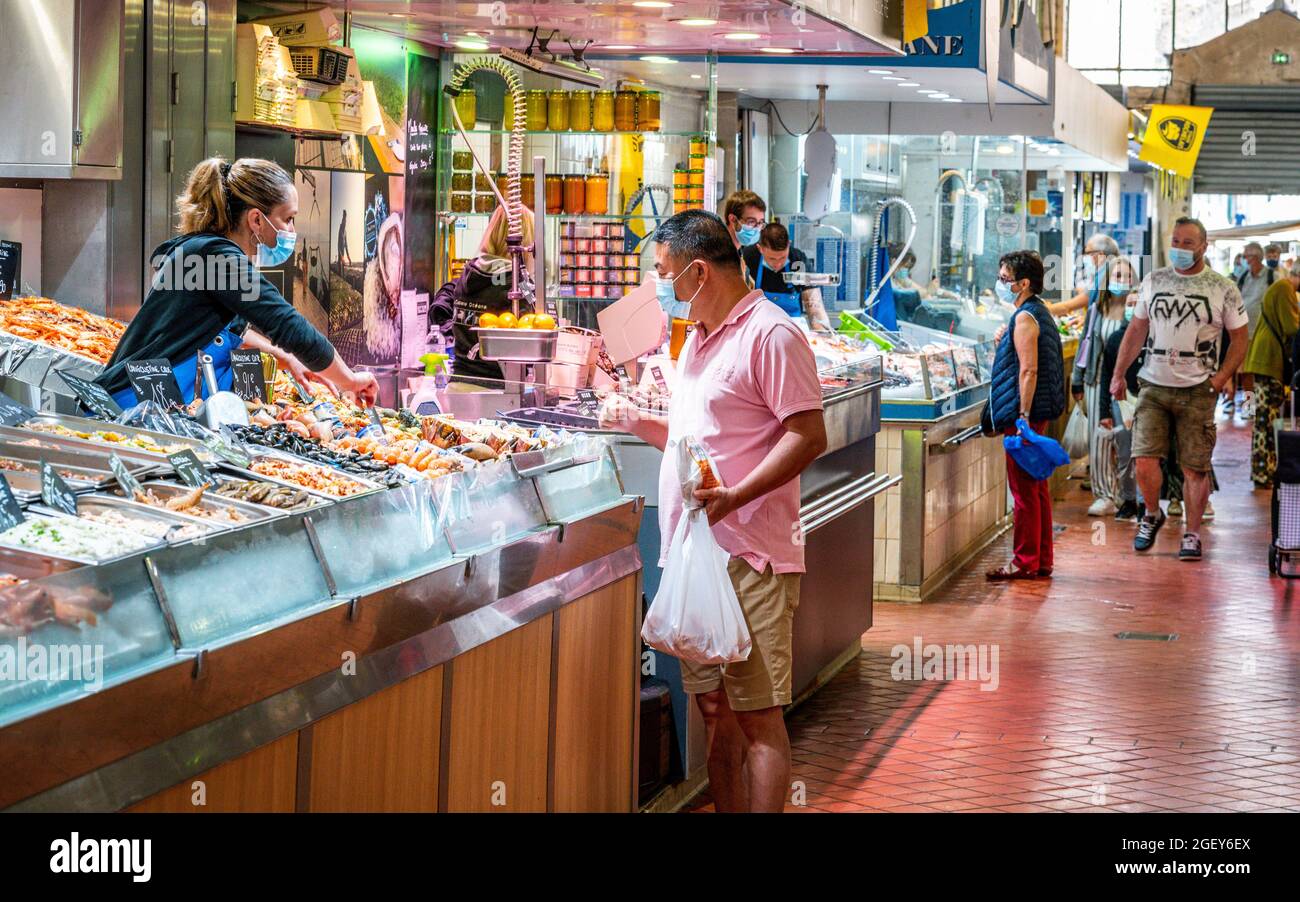 28 July 2021 , La Rochelle France : People wearing face mask shopping at the central covered market of La Rochelle during summer 2021 in France Stock Photo