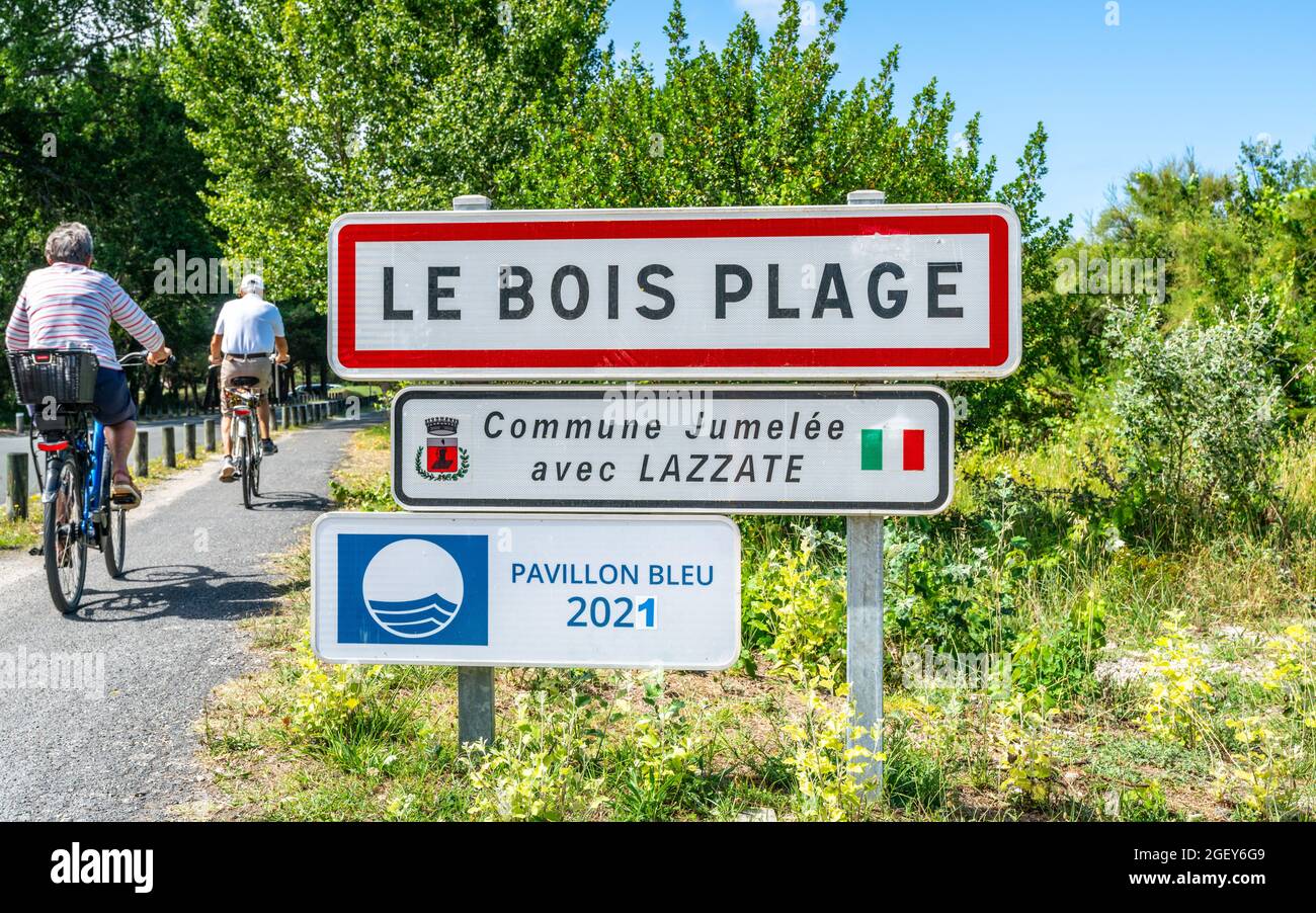 30 July 2021 , Le Bois Plage en Ré France : Le Bois Plage town sign and tourists riding a bike on Ré island France Stock Photo