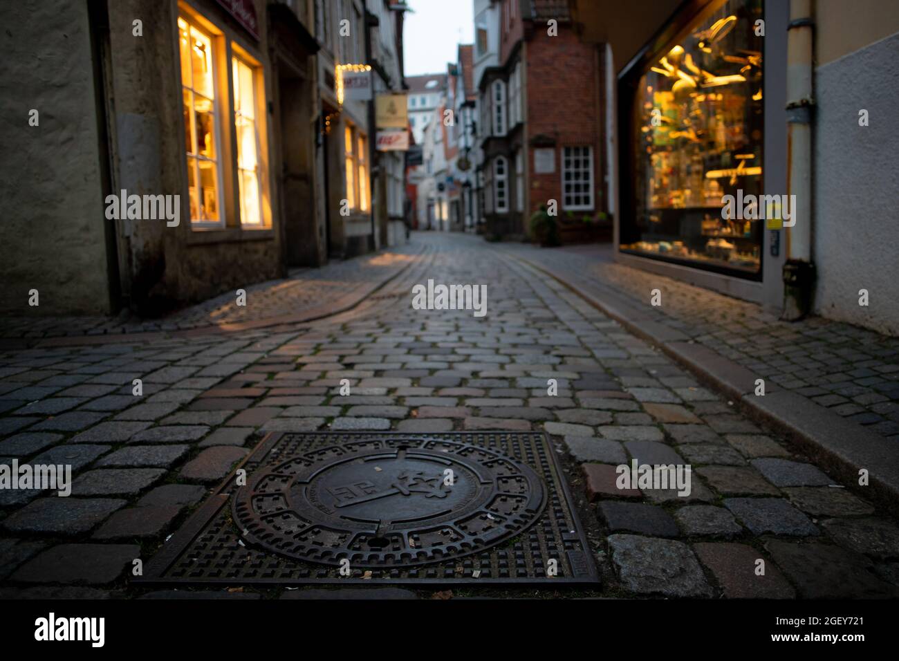 small street with beautiful pavement and ancient buildings in the famous tourist pedestrian area 'Schnoor' in Bremen, Germany in the evening Stock Photo