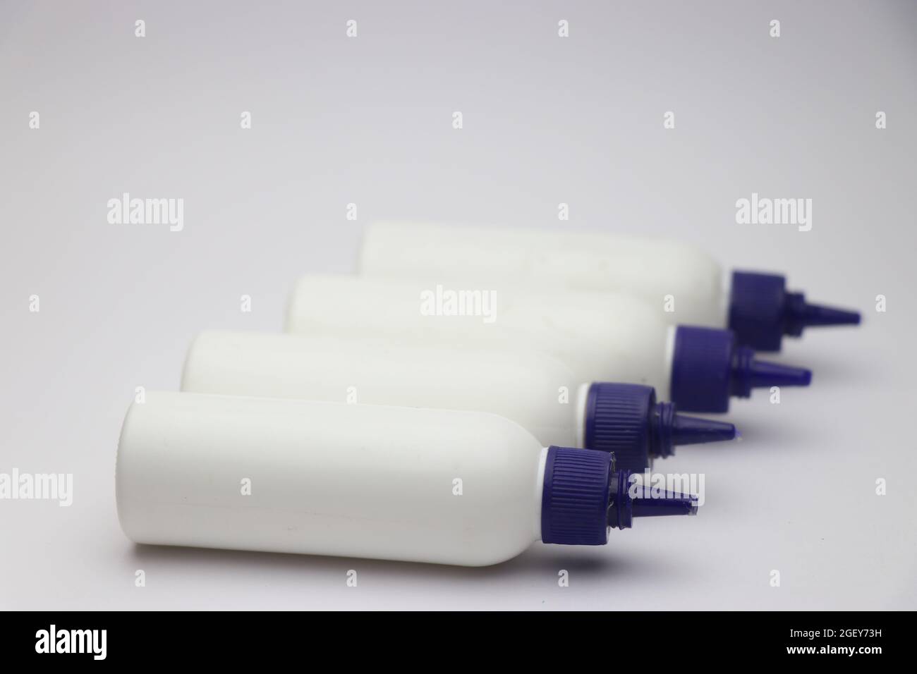 White bottle glue container. Craft supplies for sticking paper and cardboard. Glue for arts and crafts Stock Photo