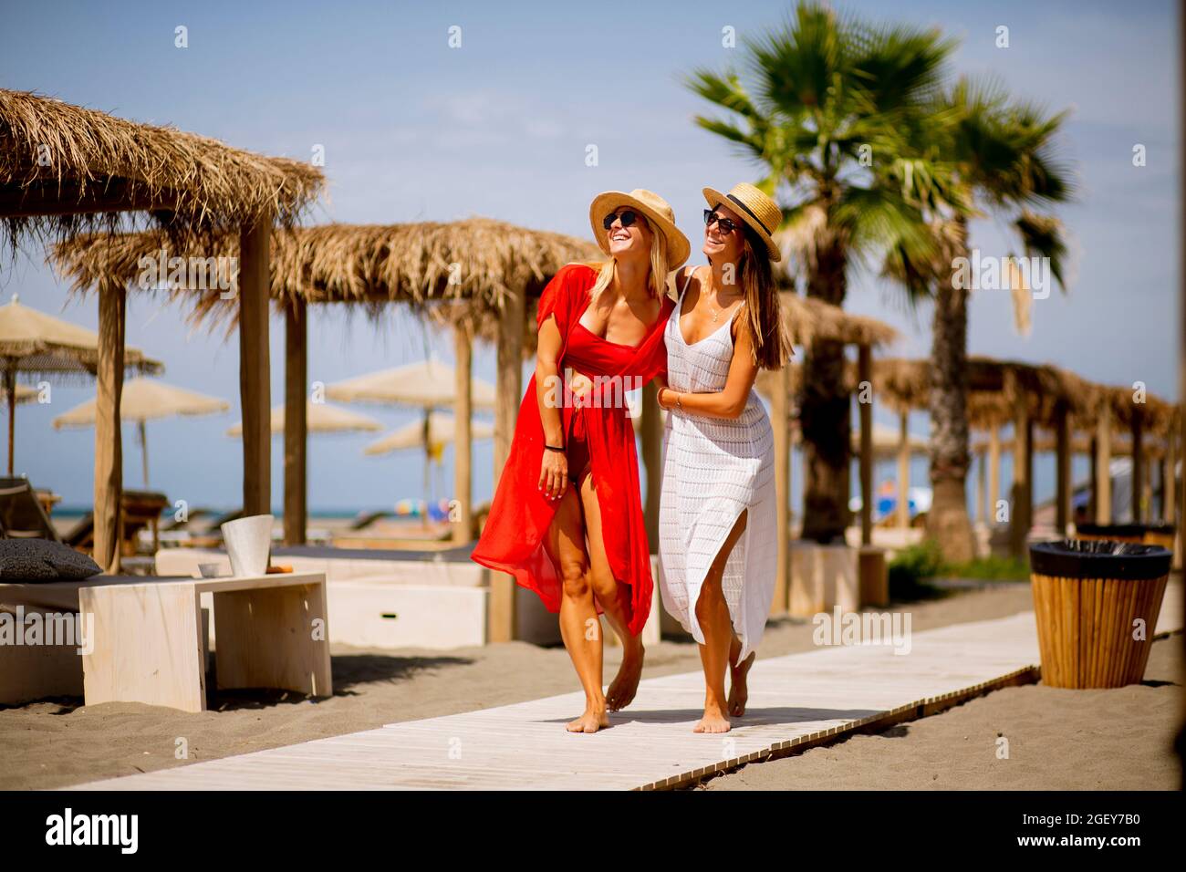 Two pretty young women walking on a beach at summer Stock Photo - Alamy