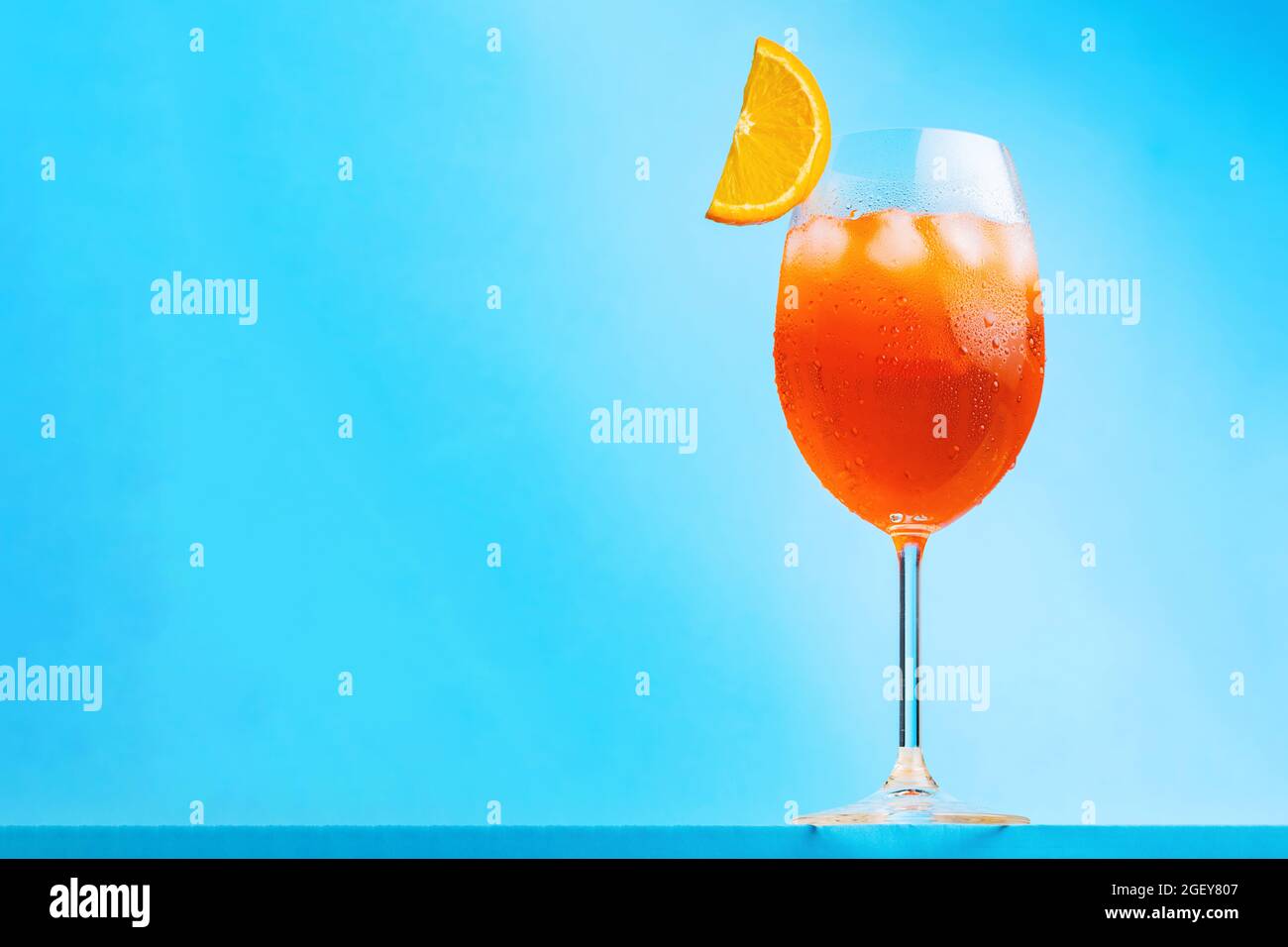 Aperol spritz cocktail on blue background. Glass of cocktail aperol spritz with a slice of orange. Italian summer cocktail. Horizontal orientation Stock Photo