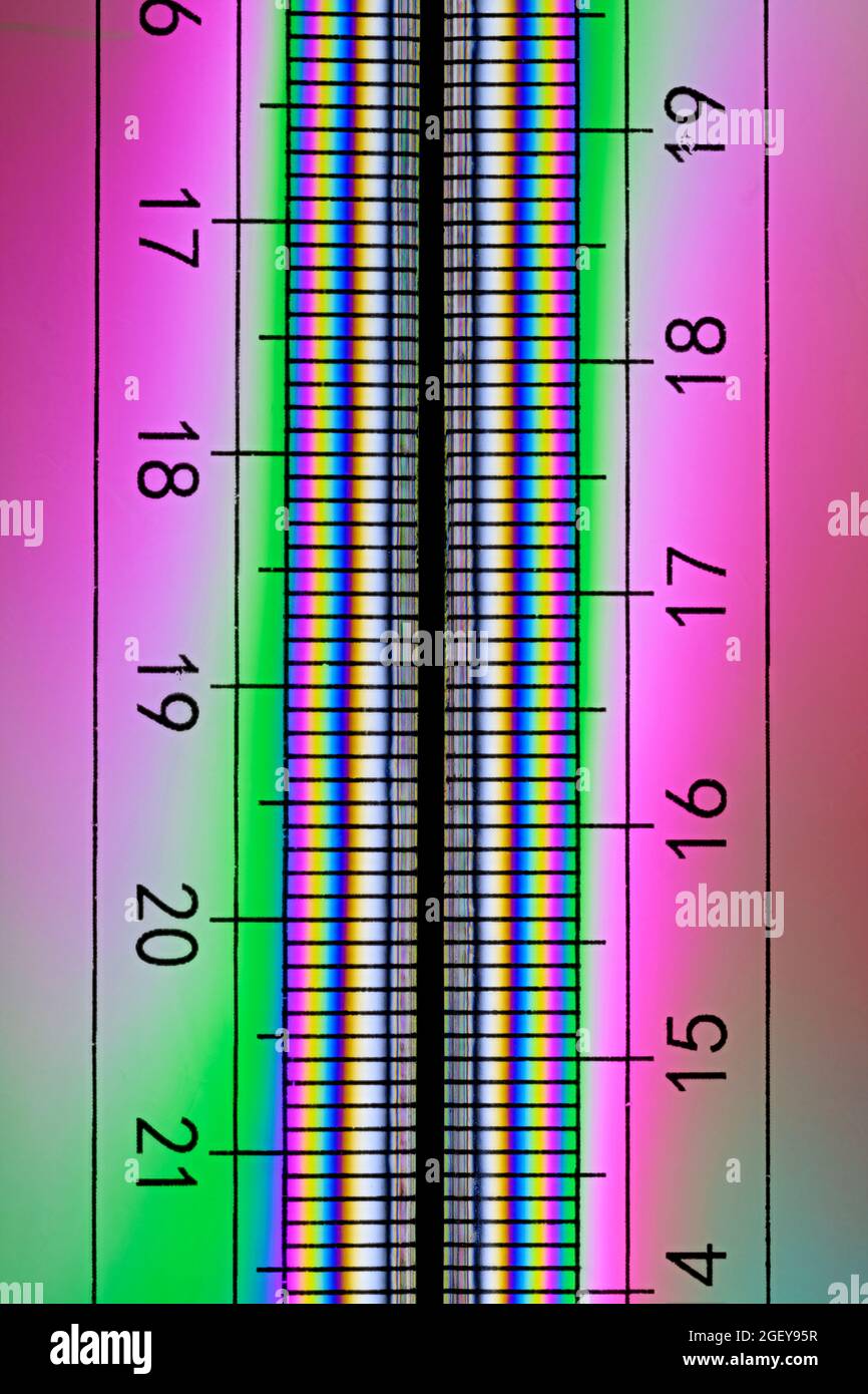 Colourful pattern on a clear plastic ruler caused by the refraction of light Stock Photo