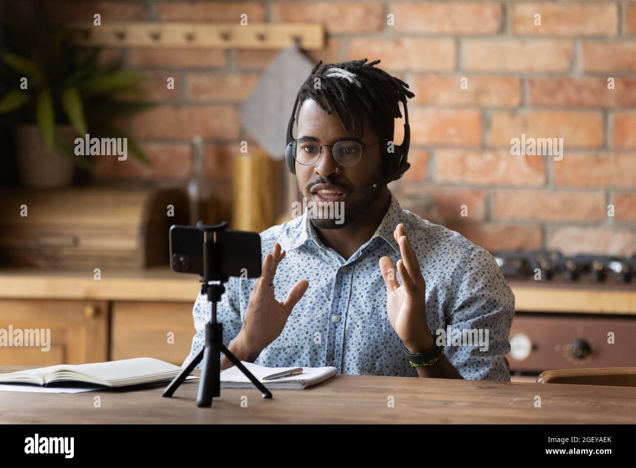 Engaged online coach giving virtual training, recording lecture on smartphone Stock Photo