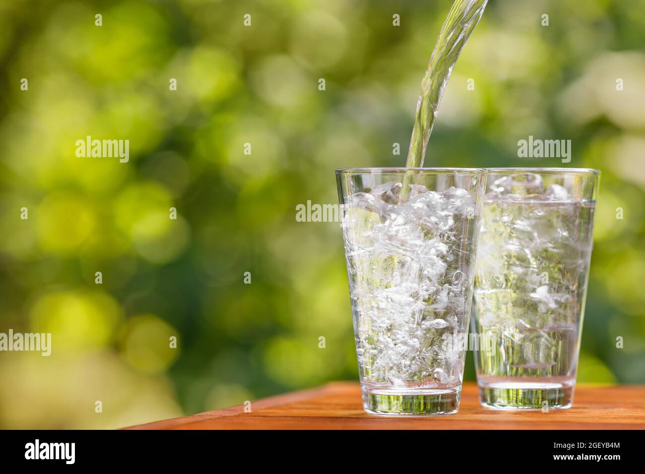 drinking pouring into glass with ice cubes Stock Photo Alamy