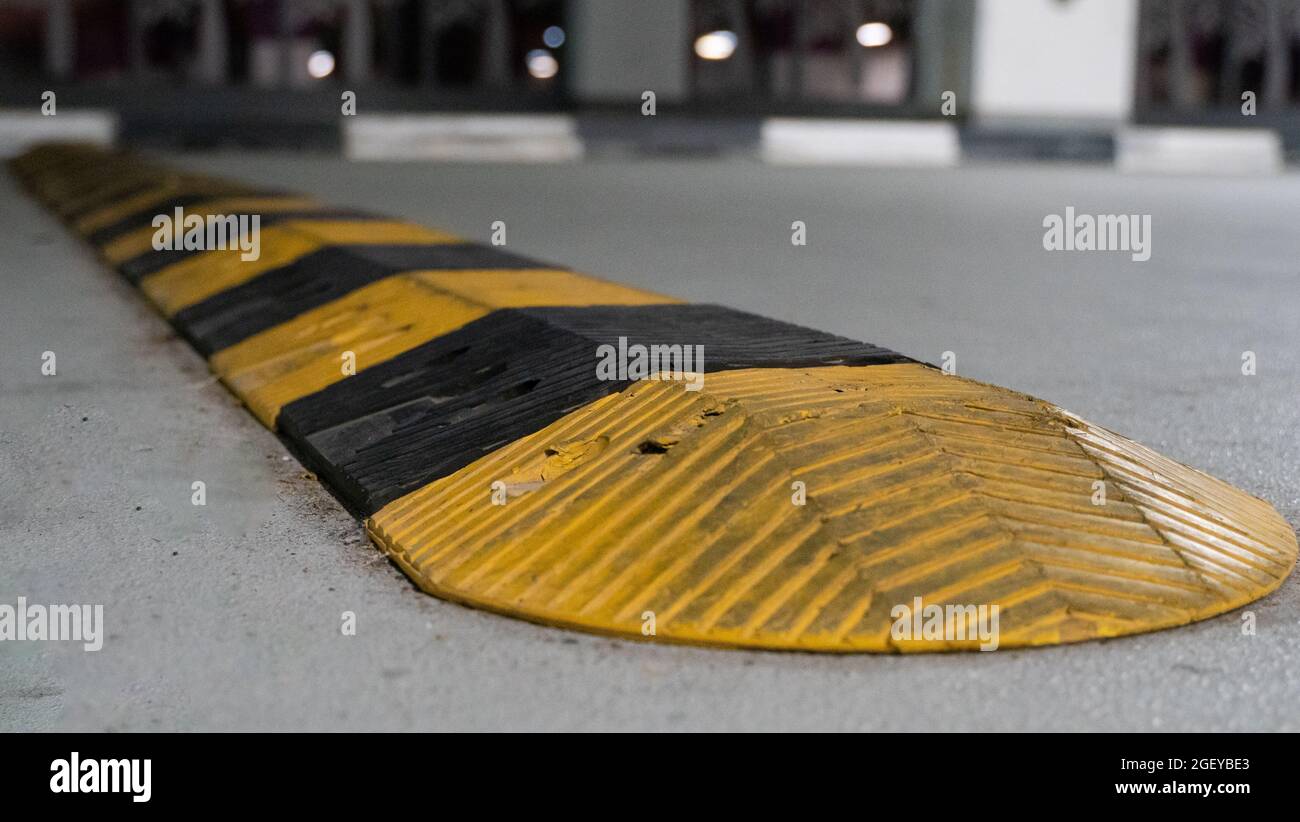 Traffic safety speed bump on an asphalt road in a parking area. Speed bumps  (or speed breakers) are the common name for a family of traffic calming de  Stock Photo - Alamy
