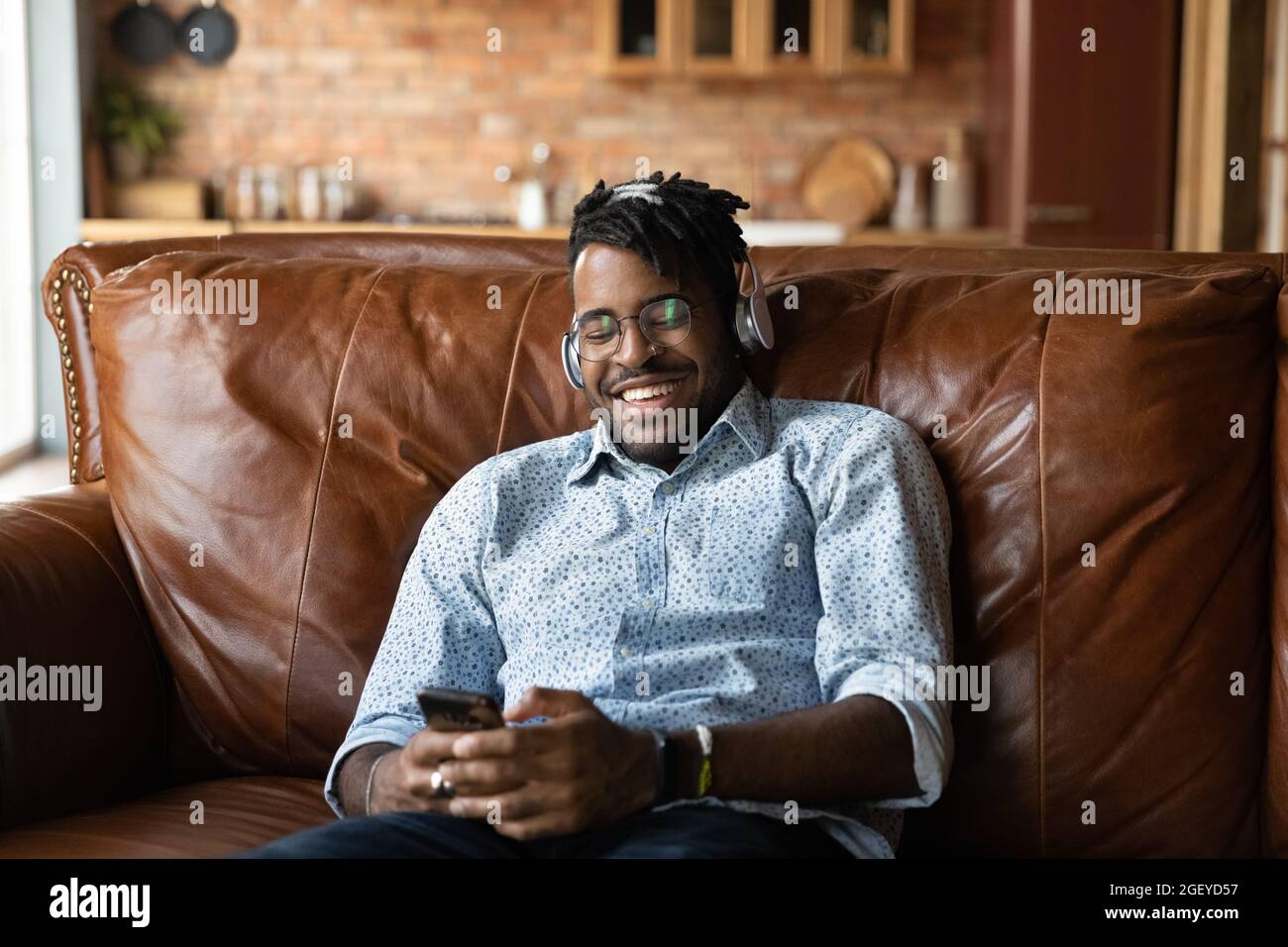 Happy millennial hipster Black guy wearing headphones Stock Photo