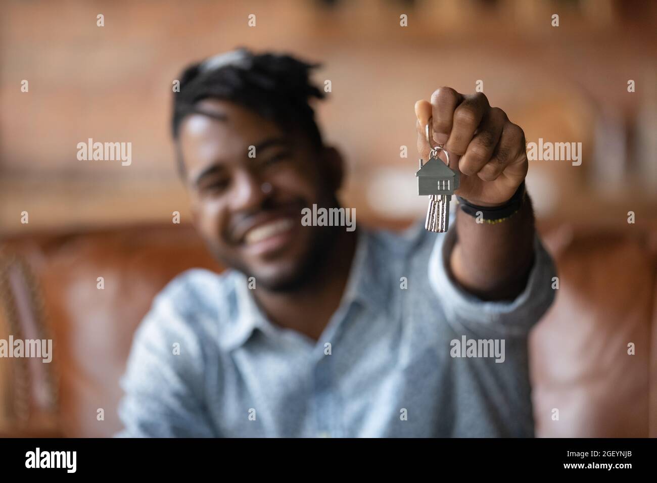 Happy African American realtor showing house key at camera Stock Photo ...