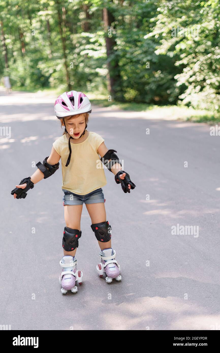 little girl learning to roller skate. Kid girl in protective sportswear  Stock Photo - Alamy
