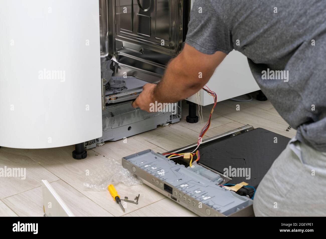 the master removes the rubber seal for repair and cleaning. dishwasher  repair Stock Photo - Alamy