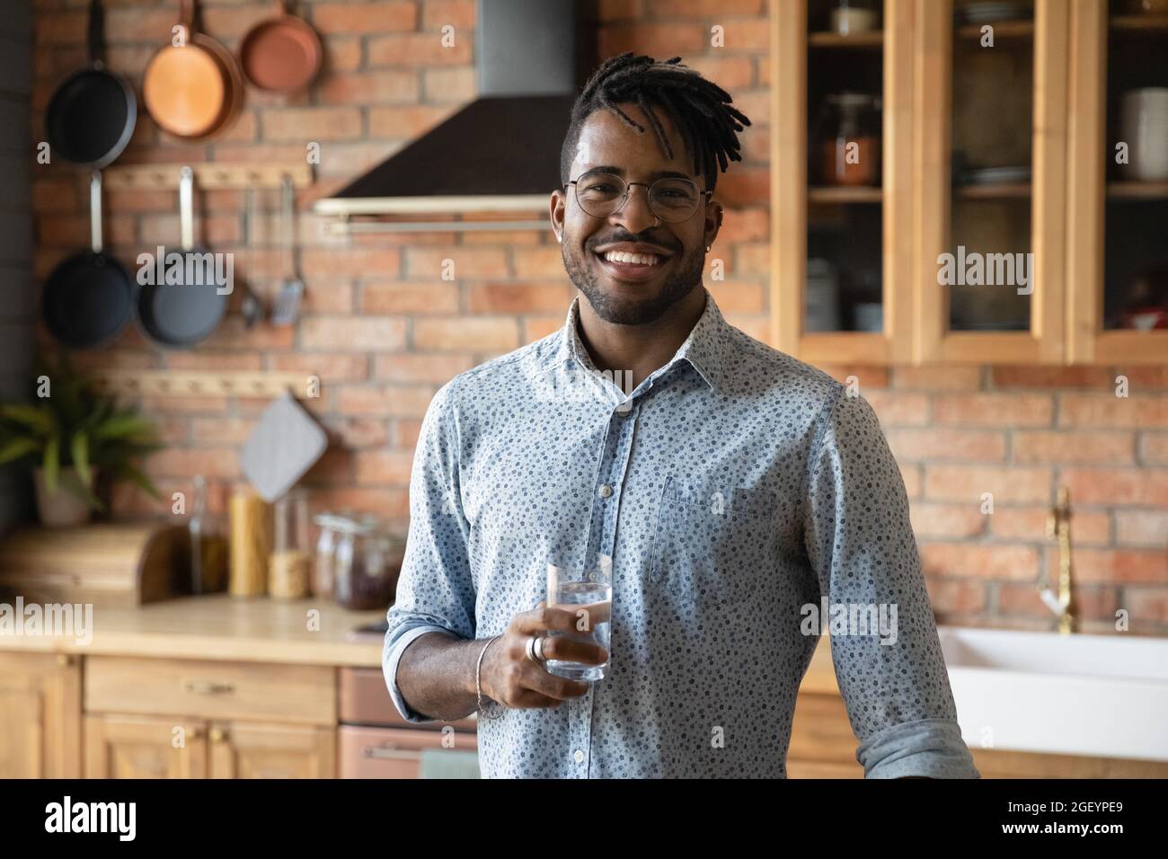 Happy handsome Black hipster guy drinking fresh pure natural water Stock Photo