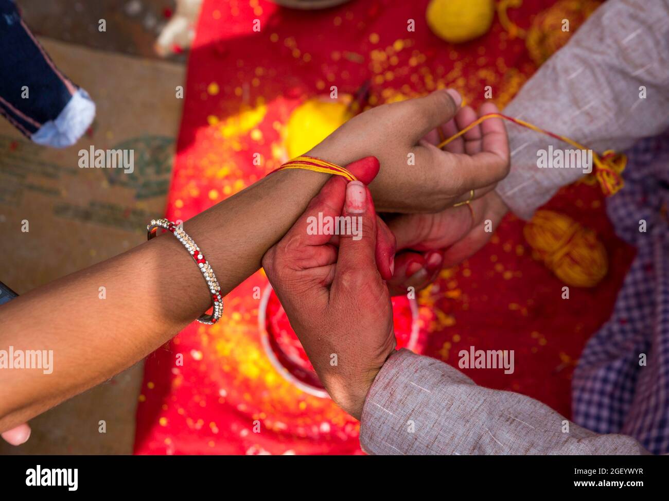 A Hindu priest ties a sacred thread on a hand of a devotee during the ...