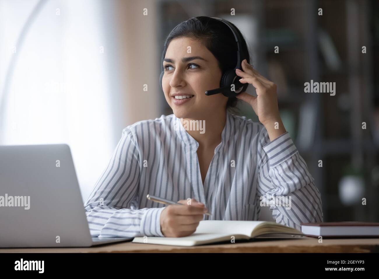 Indian female in earphones study online 
