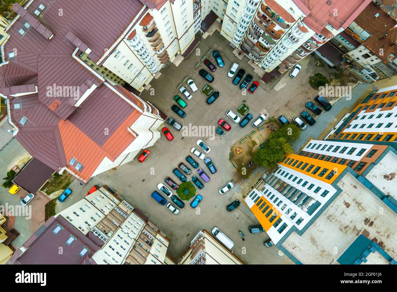 Aerial view of parked cars on parking lot between high apartment ...