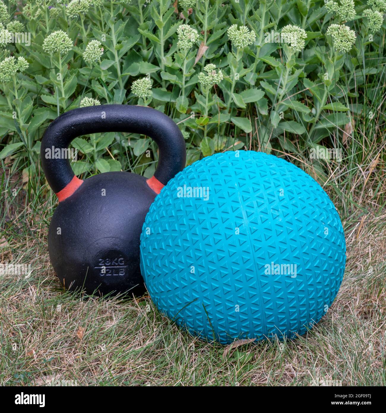 rubber slam ball filled with sand and iron kettlebell in a backyard, home  gym, exercise and fitness concept Stock Photo - Alamy