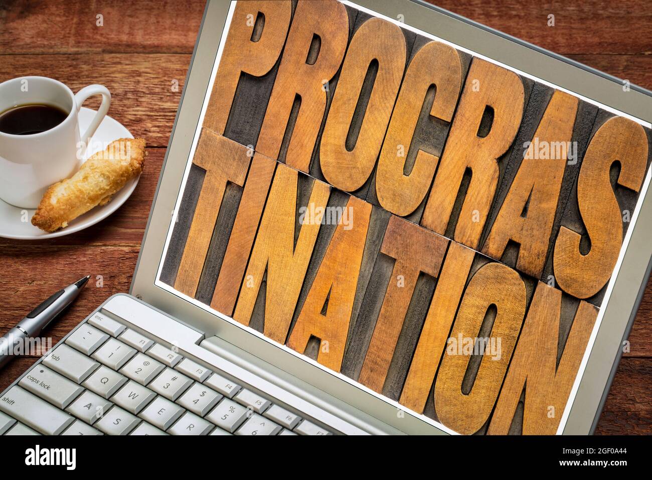 procrastination word abstract in vintage letterpress wood type on a laptop screen, efficiency and productivity concept Stock Photo