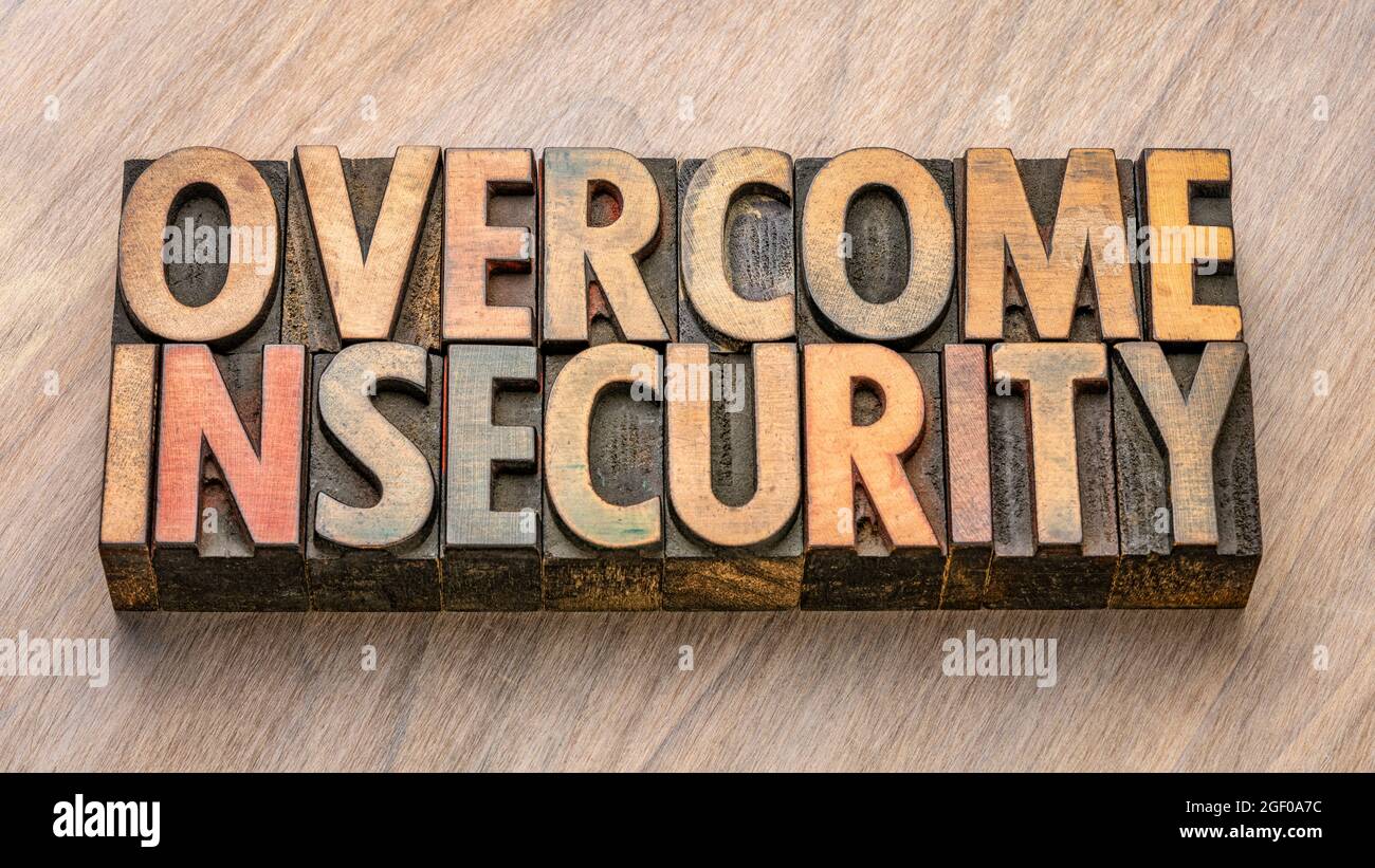 overcome insecurity word in vintage letterpress wood type, confidence and personal development concept Stock Photo
