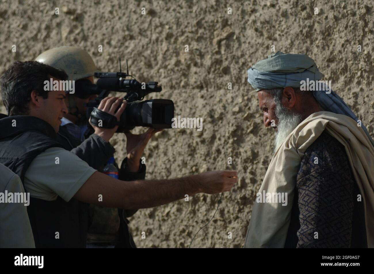 An ABC News reporter interviews a local Afghan elder as part of a Key Leader Engagement with Afghanistan national security forces members as part of a training mission at Khanjarkhe, Parwan province, Afghanistan during a training mission. ANSF commandos take part in in their first training mission as they attend the ANSF Air Assault Academy at Bagram Airfield, Afghanistan, March 10. Stock Photo