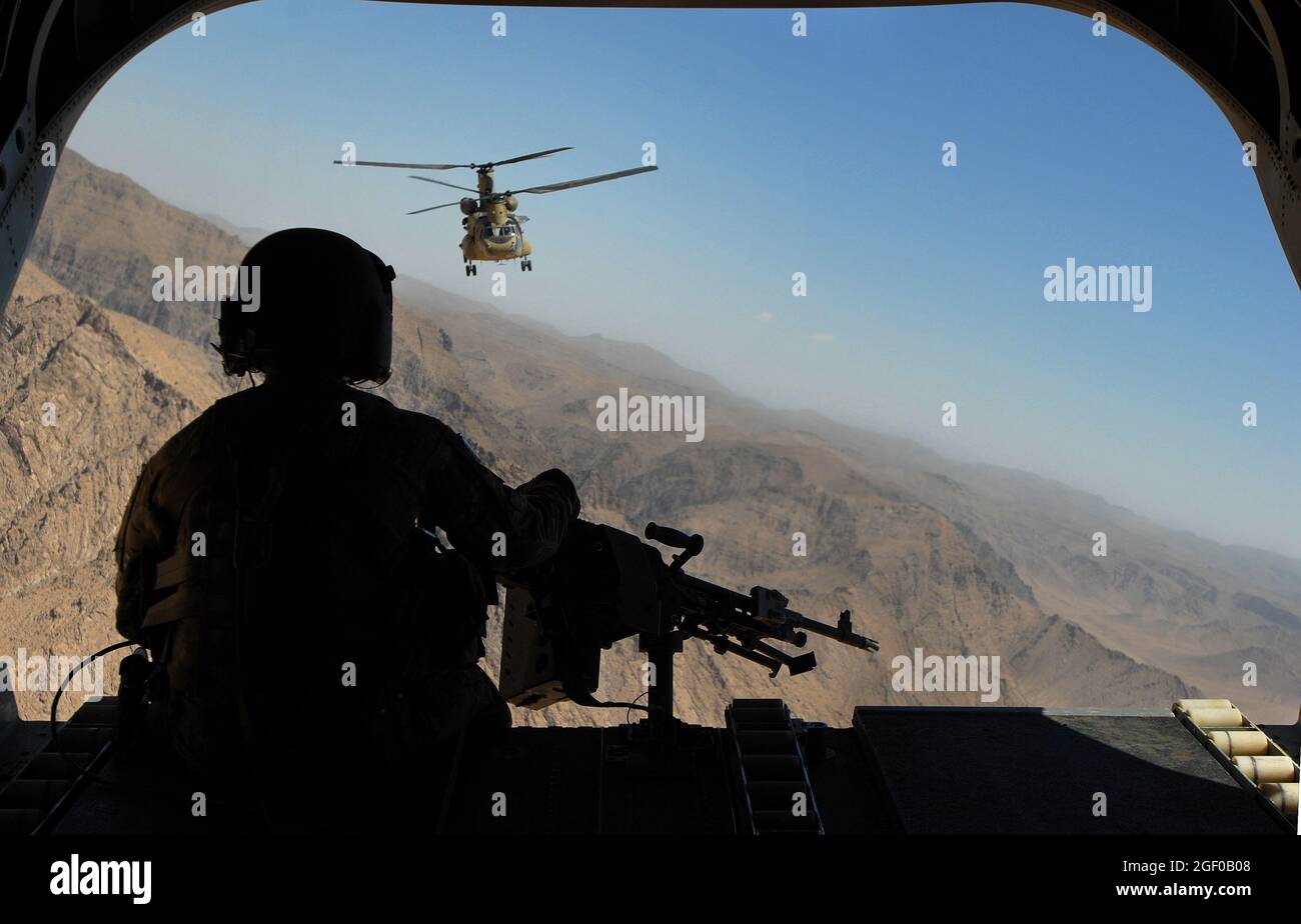 Sgt. Zach Smola, rear door gunner on a CH-47, keeps watch on the mountains in Uruzgan province, Afghanistan, May 12, 2013. The Chinooks, operated by members of Bravo Company, 2nd Battalion, 104th Aviation Regiment from the Connecticut and Pennsylvania Army National Guard , have played a vital part in the mission in Afghanistan since their arrival in Dec. 2012 by performing resupply, retrograde, and planned missions. (U.S. Army photo by Sgt. Jessi Ann McCormick) Stock Photo