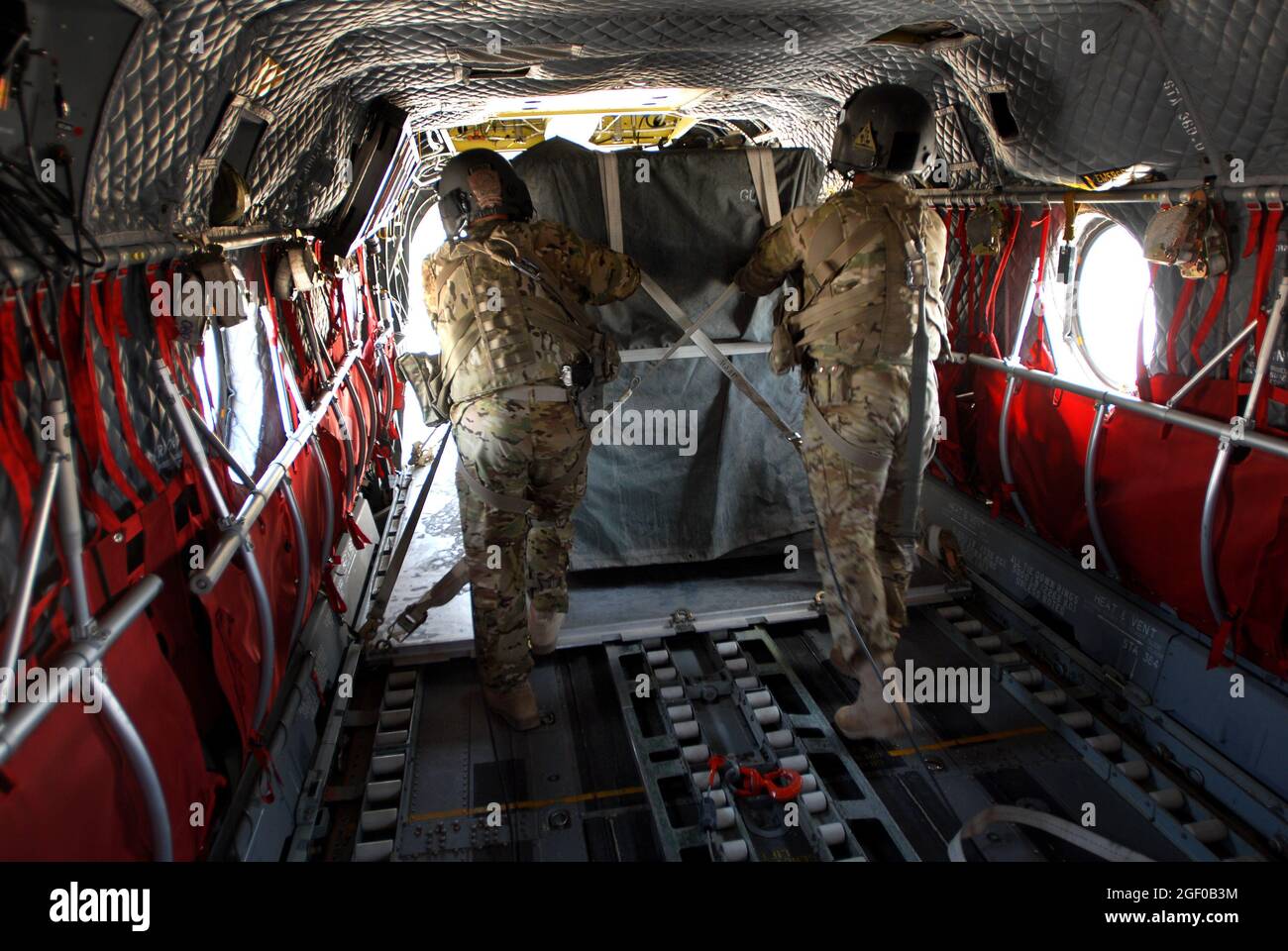 Master Sgt. Guy Miller (left) and Sgt. Shawn Adams unload cargo from a CH-47 Chinook in Uruzgan province, Afghanistan, May 12, 2013. The Chinooks, operated by members of Bravo Company, 2nd Battalion, 104th Aviation Regiment from the Connecticut and Pennsylvania Army National Guard, have played a vital part in the mission in Afghanistan since their arrival in Dec. 2012 by performing resupply, retrograde, and planned missions. (U.S. Army photo by Sgt. Jessi Ann McCormick) Stock Photo
