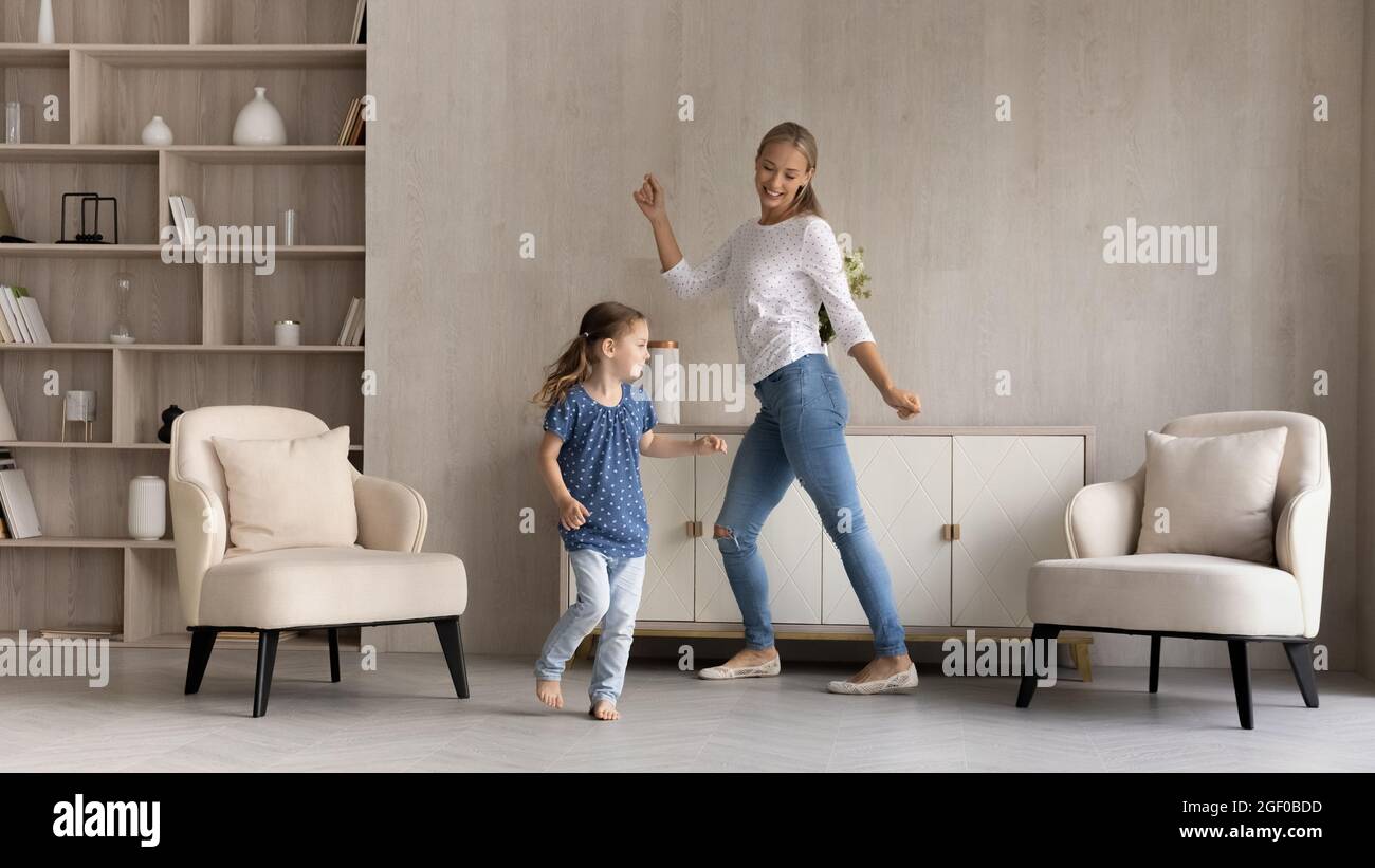 Happy little girl and mom dancing to music at home Stock Photo - Alamy
