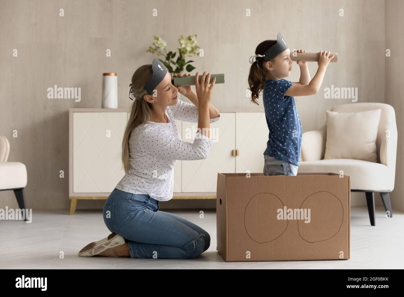 Happy mother and daughter kid looking forward through toy paper Stock Photo