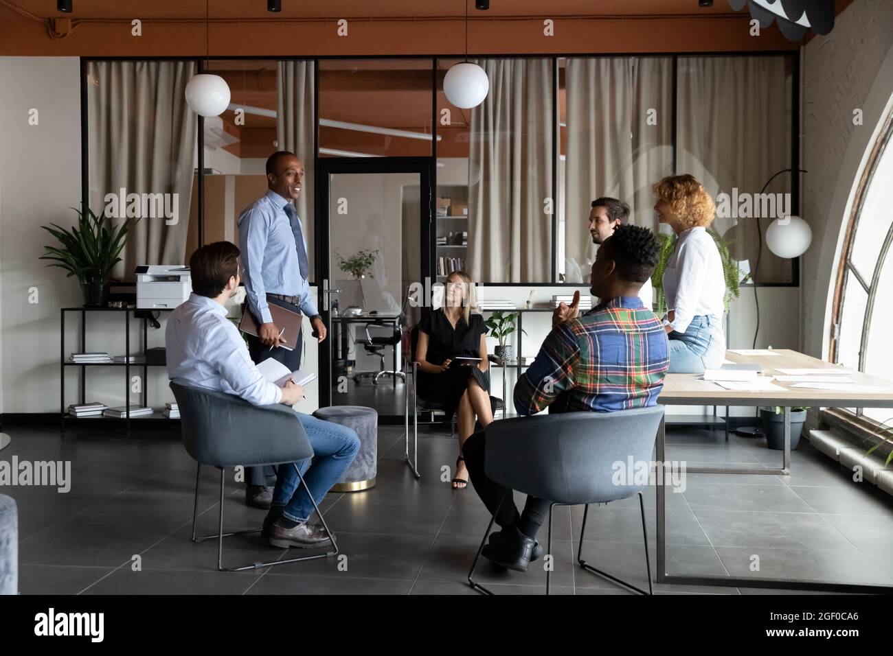 Multiethnic businesspeople talk discuss ideas at meeting Stock Photo