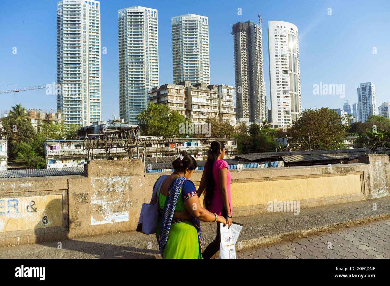 Mumbai, Maharashtra, India : Women walk past high rise buildings in southern Mumbai. Stock Photo