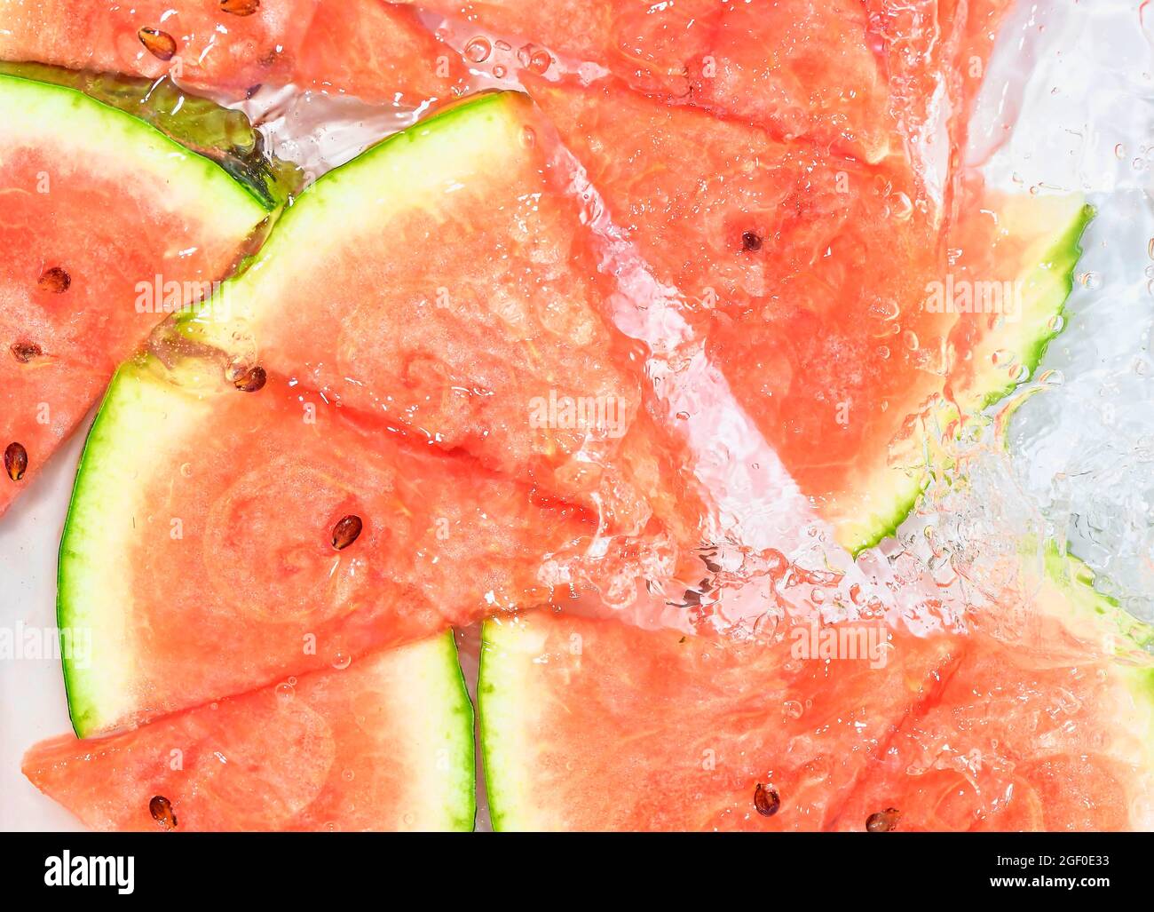 Melon closeup in liquid with bubbles. Slicec of red ripe melon in