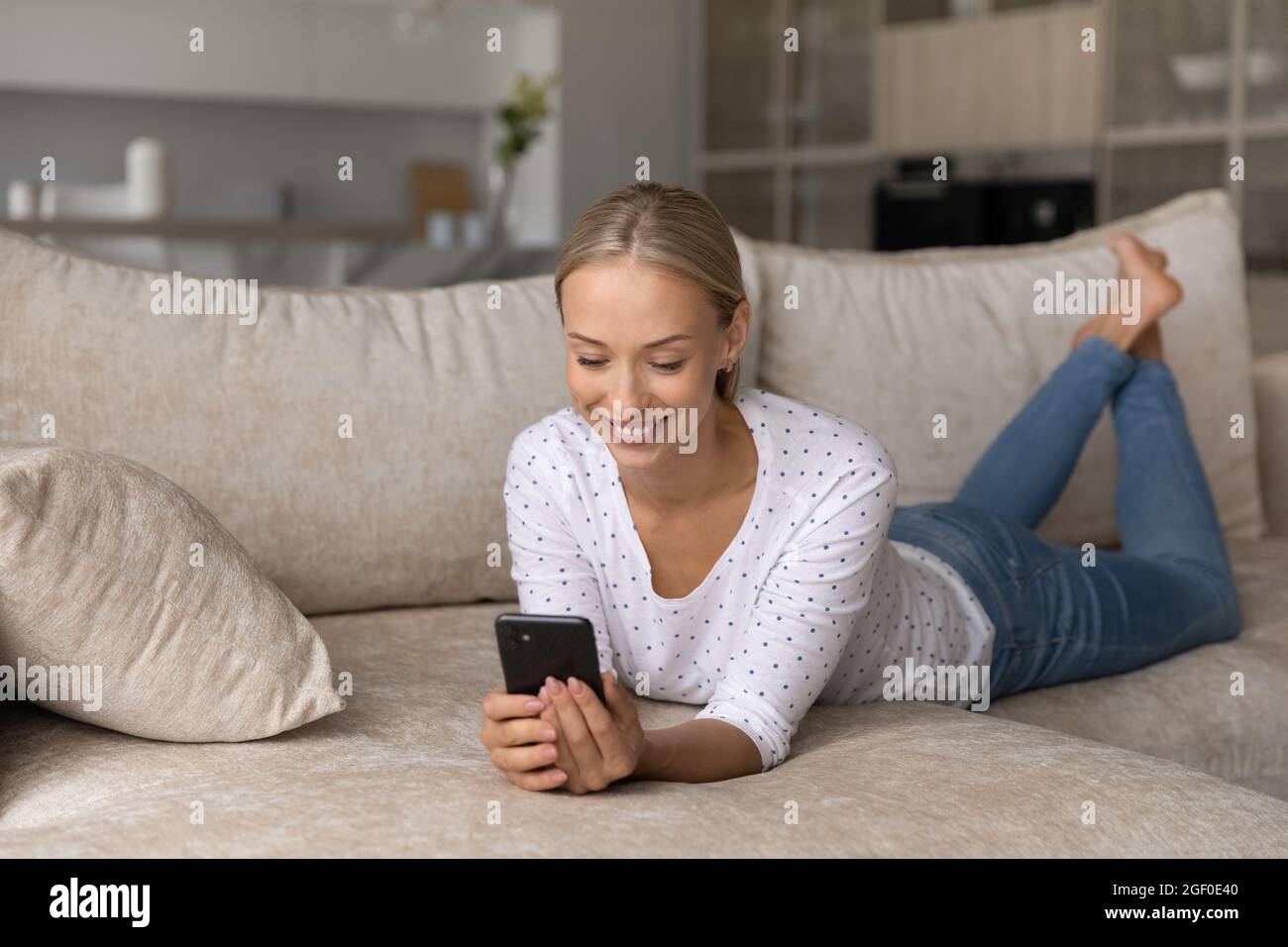 Happy woman using smartphone for online chat, enjoying virtual talk Stock Photo
