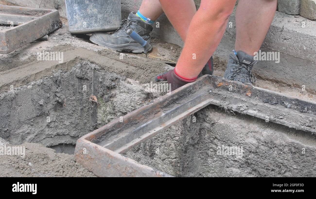 Worker making base for sewer grill. Bulding worker concept Stock Photo