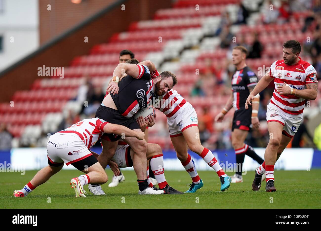 Salford Red Devils’ Greg Burke is tackled by Leigh Centurions’ Rob Butler and Keanan Brand during the Betfred Super League match at the Leigh Sports Village, Leigh. Picture date: Sunday August 22, 2021. Stock Photo