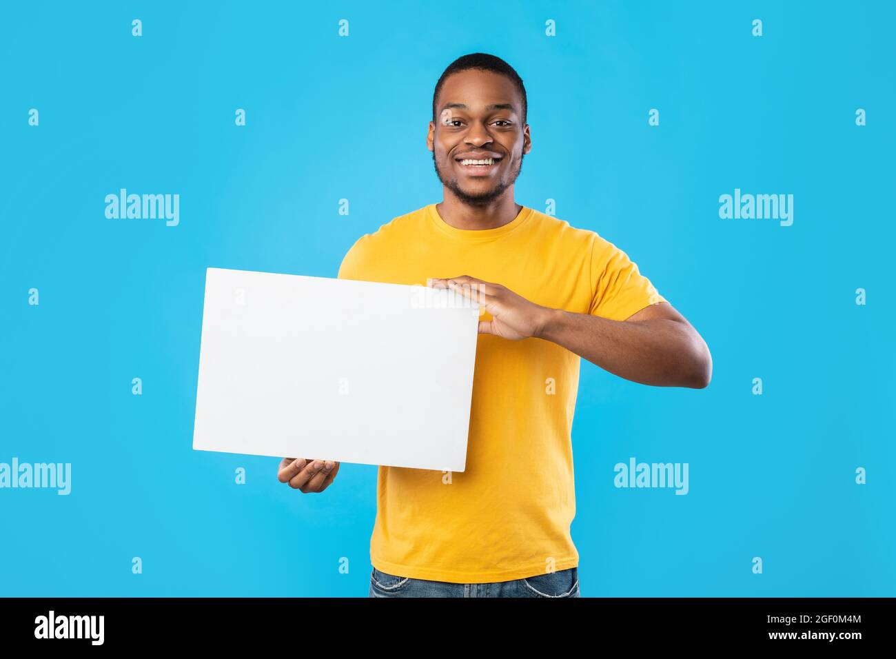 Black Man Showing Poster With Space For Text, Blue Background Stock Photo