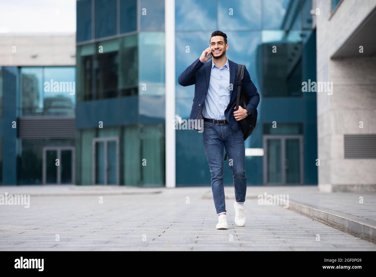 Young middle-eastern entrepreneur going home, talking on phone Stock Photo