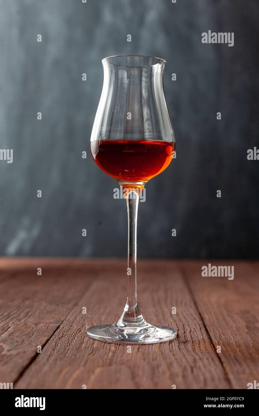 Grappa glass with brandy or sherry or calvados on wooden table Stock Photo  - Alamy