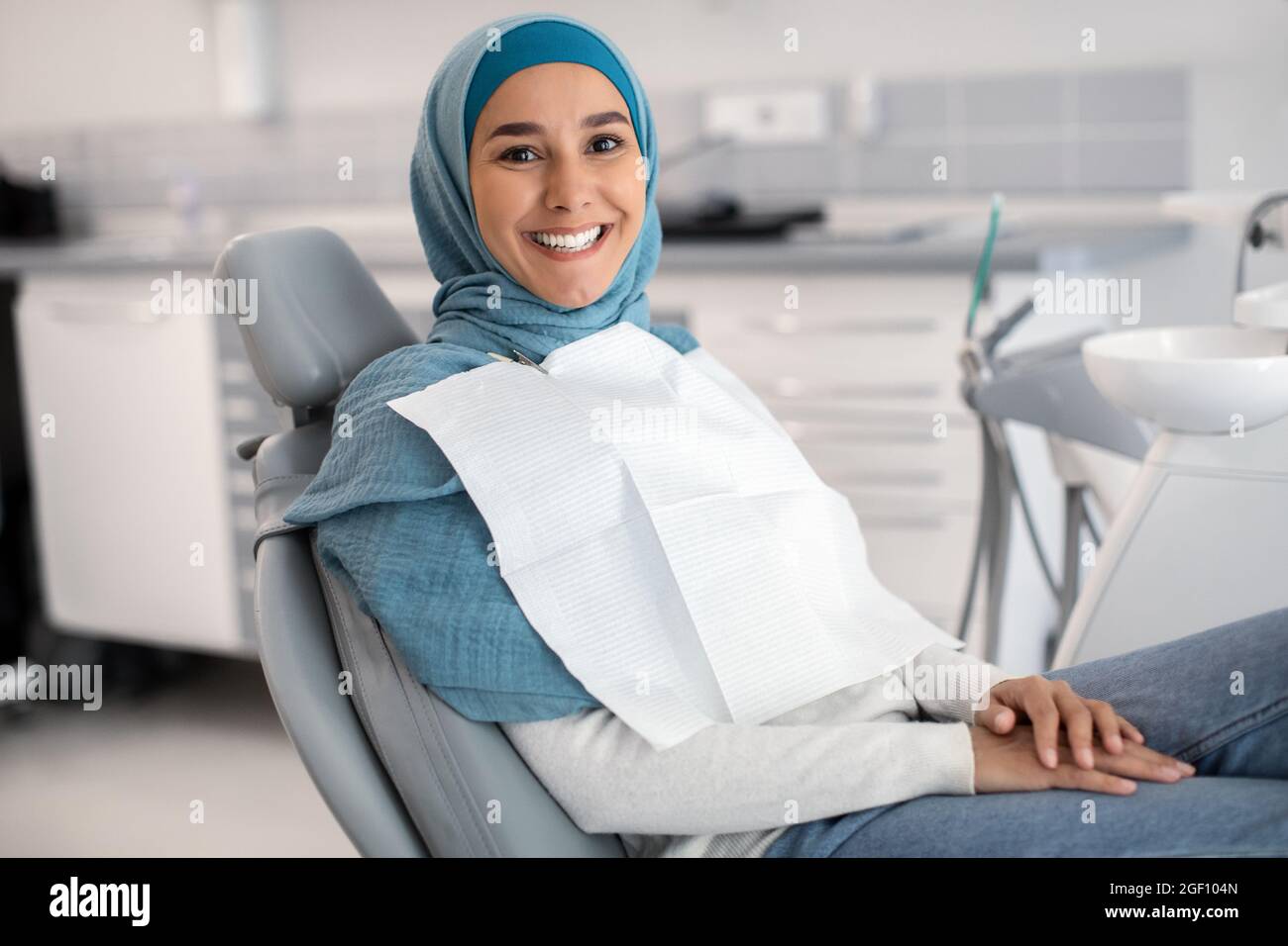 Happy Islamic Lady In Hijab Sitting In Chair At Dental Clinic Stock