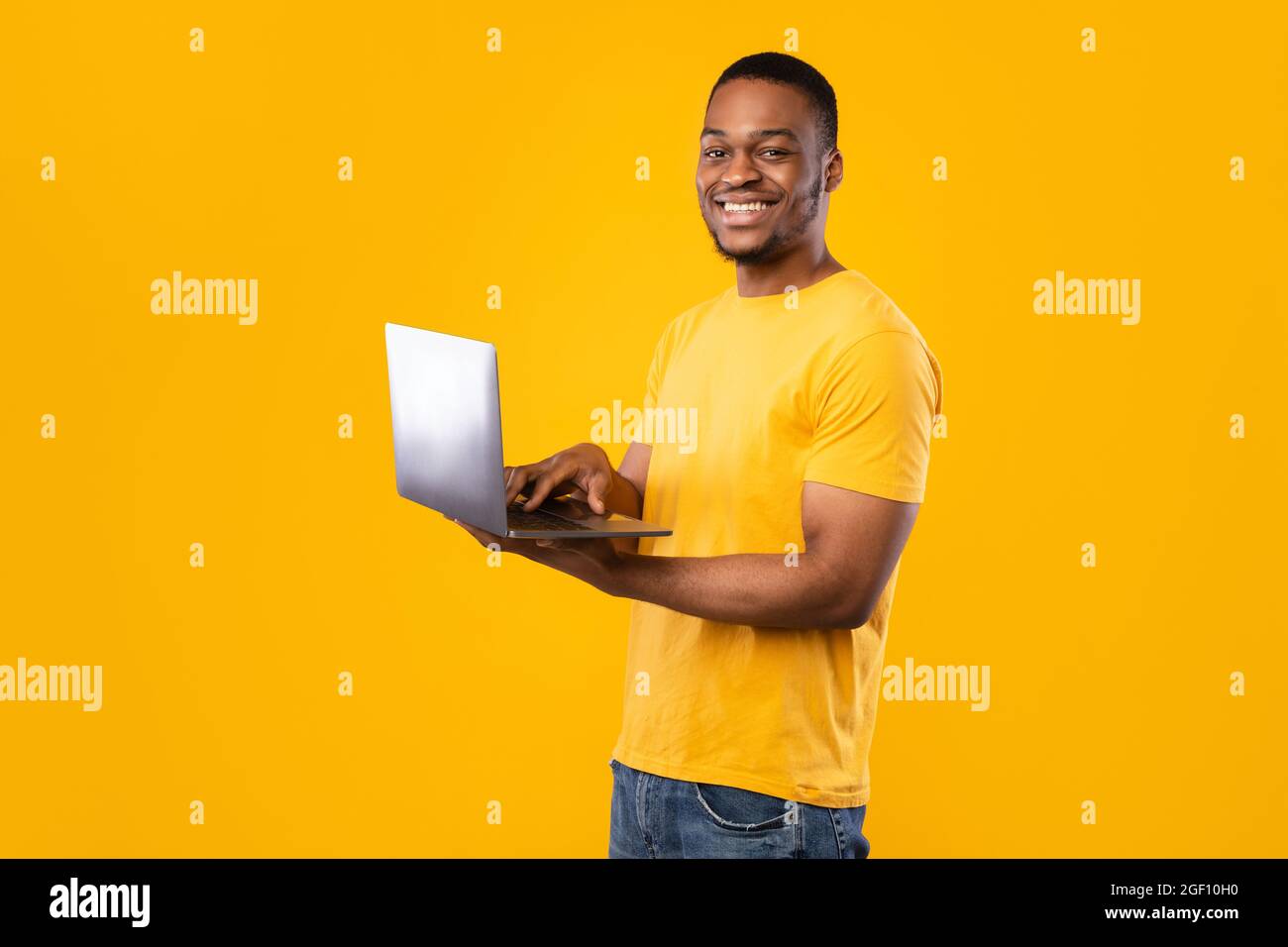 Happy Black Guy Using Laptop Computer Standing Over Yellow Background ...