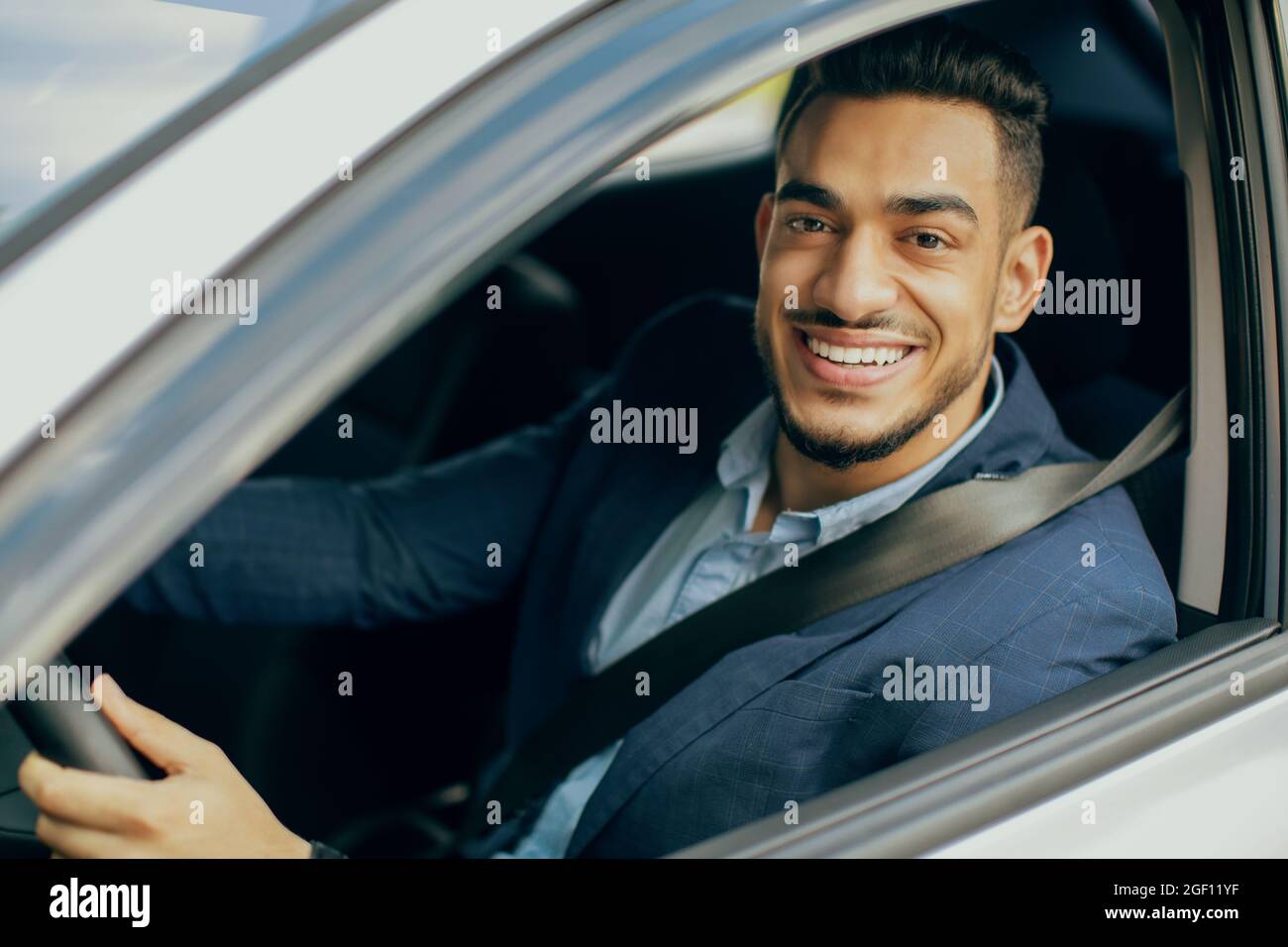 Portrait of smiling middle-eastern businessman driving car Stock Photo