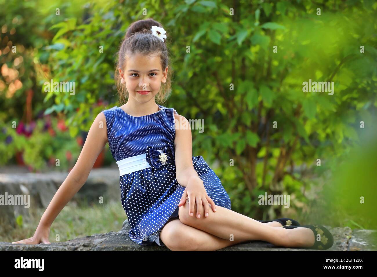 beautiful brunette girl in a blue polka dot dress in the summer in the ...