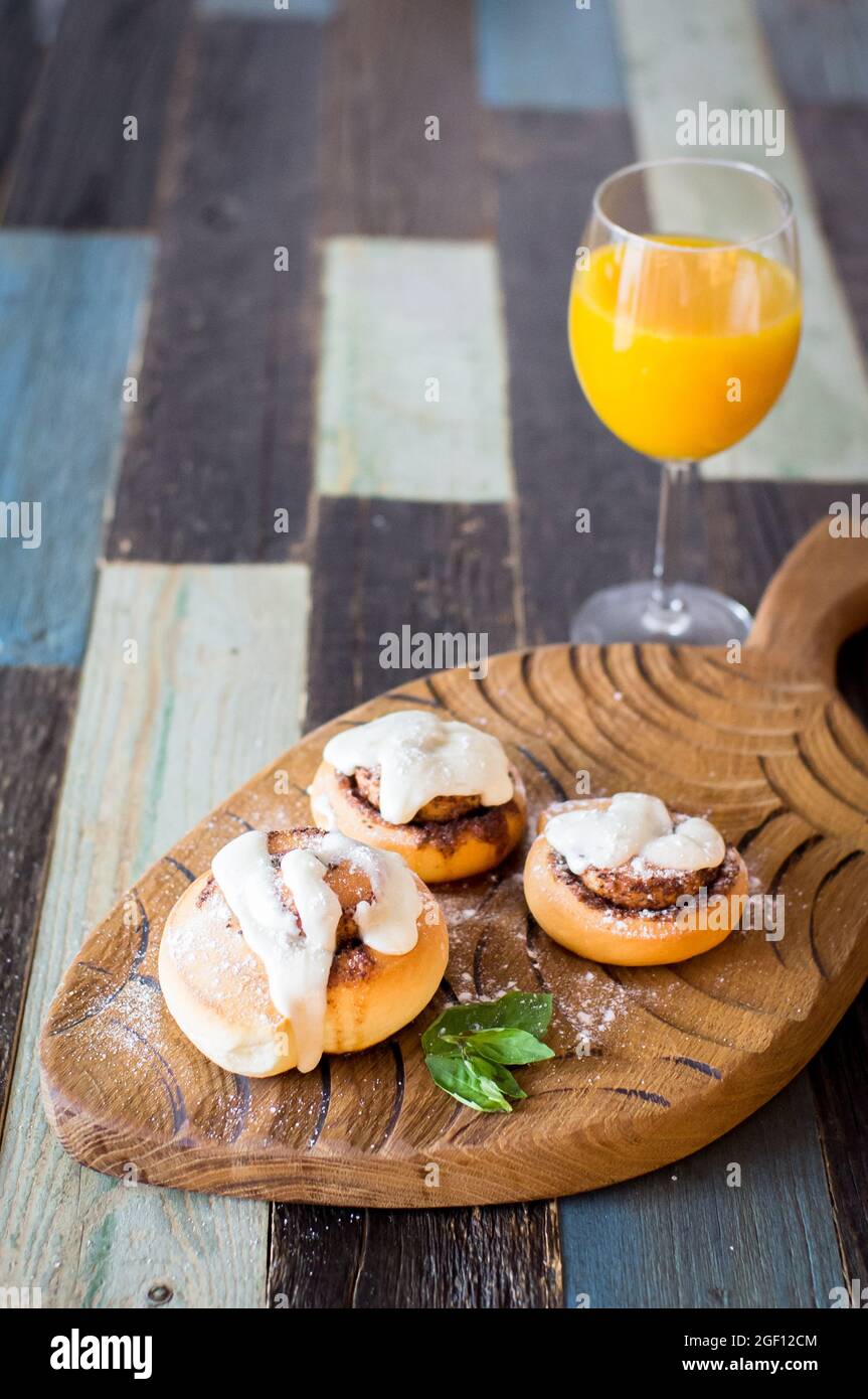 Homemade buns with cinnamon and a glass of juice Stock Photo Alamy