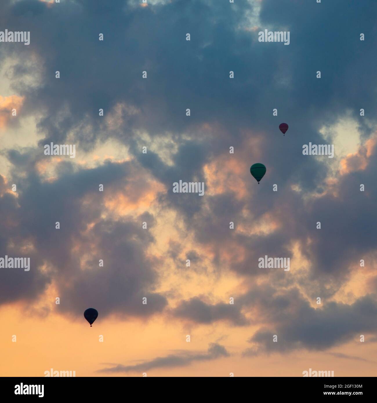 three hot air balloons in colorful sky with clouds Stock Photo - Alamy