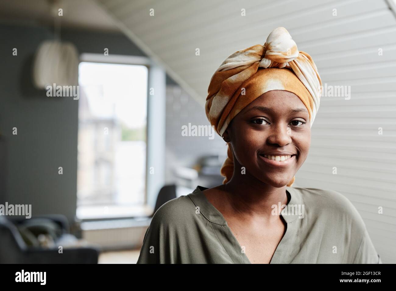 Portrait of young African-American woman smiling at camera in home ...