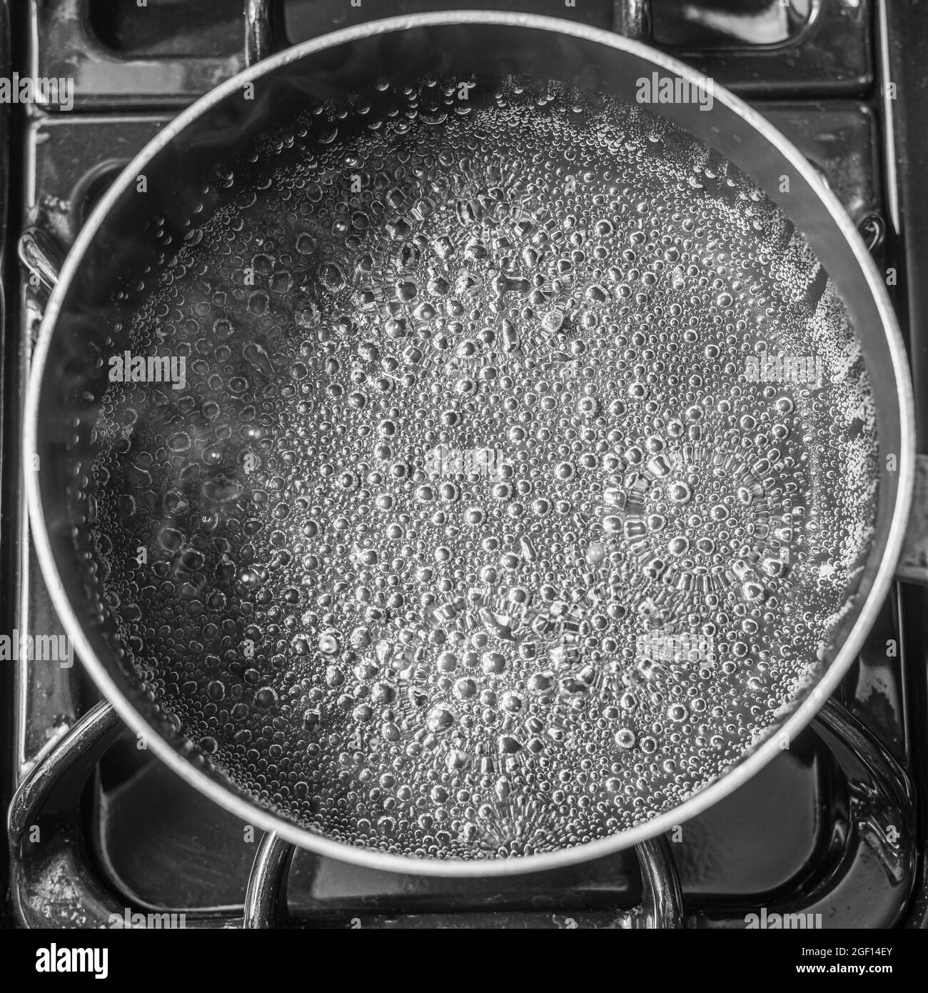 A top view of an empty pan with bubbles and steam rising from it on a