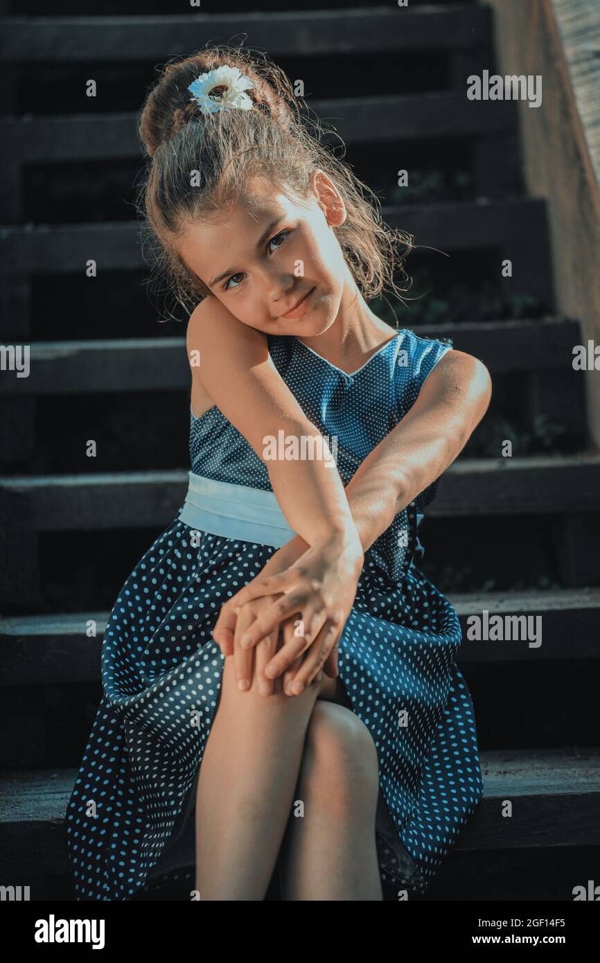 beautiful brunette girl in a blue polka dot dress on the steps of the ...