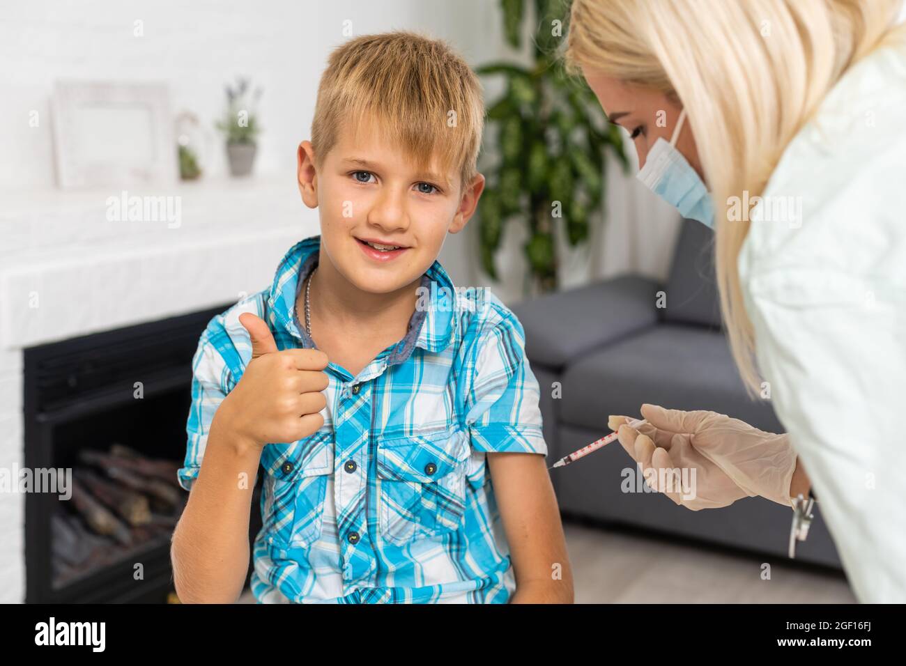 Young boy receiving vaccination immunisation by professional health worker Stock Photo