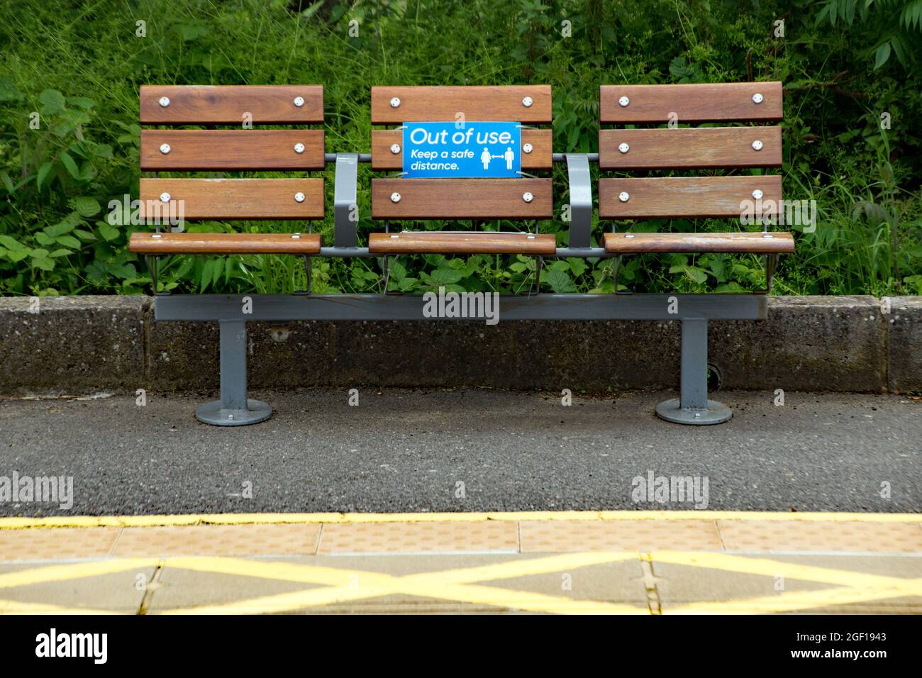 A covid-19 safe seating arrangement at a rail station in Hertfordshire. This small village station has the seats in the open by the woods.  Keeping al Stock Photo