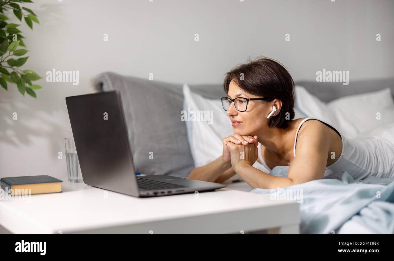 Woman lying on bed with laptop hi-res stock photography and images - Alamy