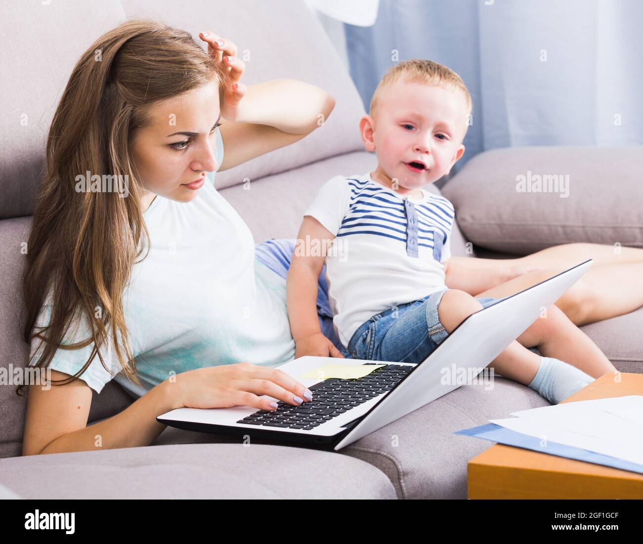 Perplexed Kids Perplexed female is having problems with child while working Stock ...