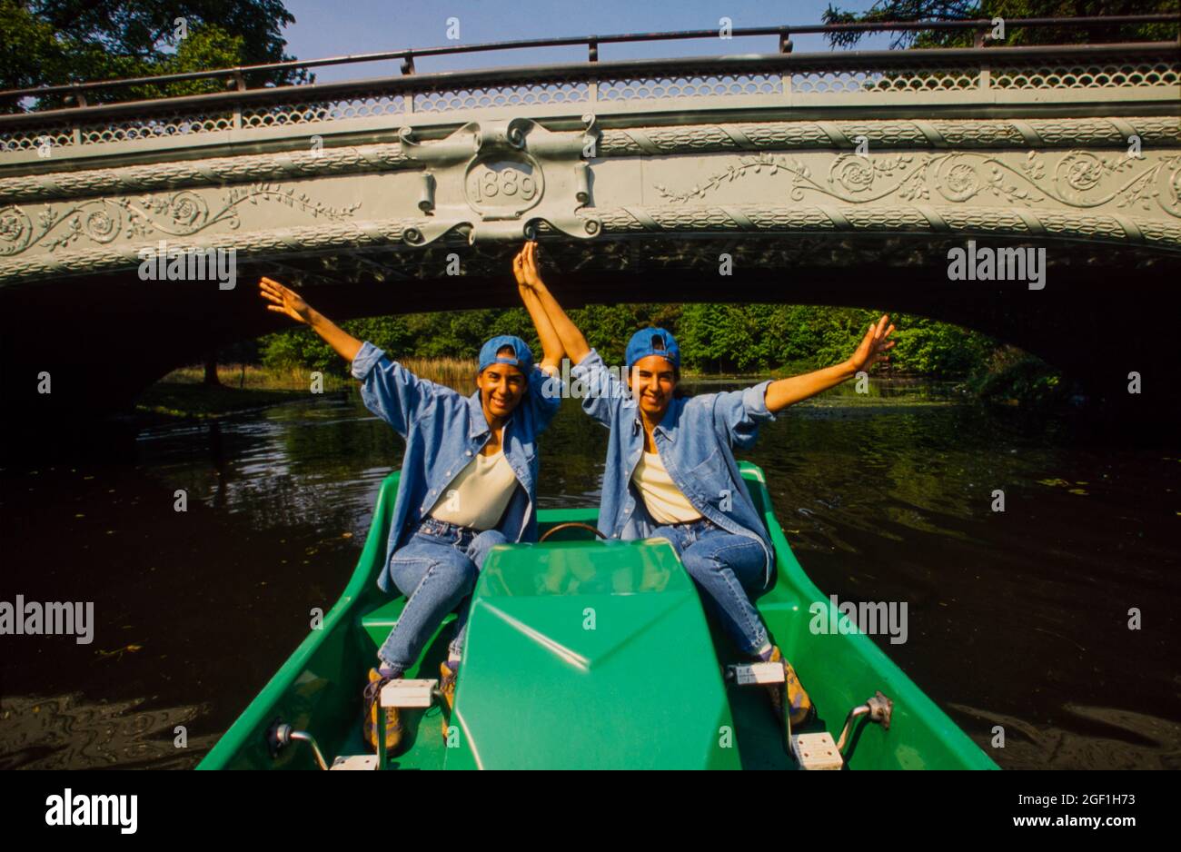 twin young adult women riding paddle boat in Prospect park lake