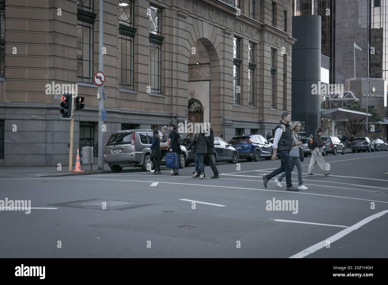 Wellington New Zealand - July 30 2021; Grainy old world style urban street scene with couple crossing outside Old Bank Building on intersection of Cus Stock Photo